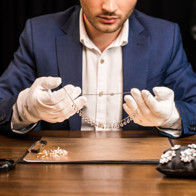 Jewelry expert holding necklace