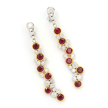 Diamond and ruby dangling earrings in a gold setting.