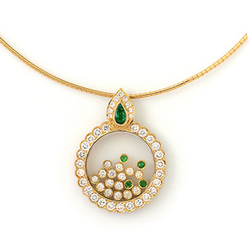 Emerald and diamond pendant with a gold necklace.